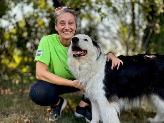 Alessia De Luca abbraccia un grande cane bianco e nero