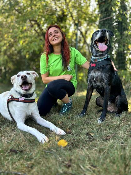 Martina Benzi accovacciata tra un cane bianco e un cane nero