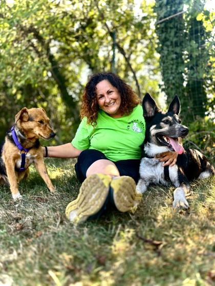 Stefania Di Martino seduta sul prato con due cani